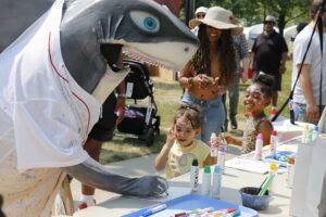 The Art Shark mascot interacts with kids