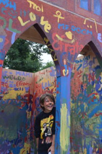 A child interacts with painted backdrops at the Arts Festival kids area