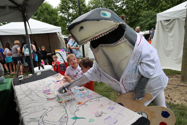 Columbus Arts Festival mascot Art Shark participates in a drawing activity