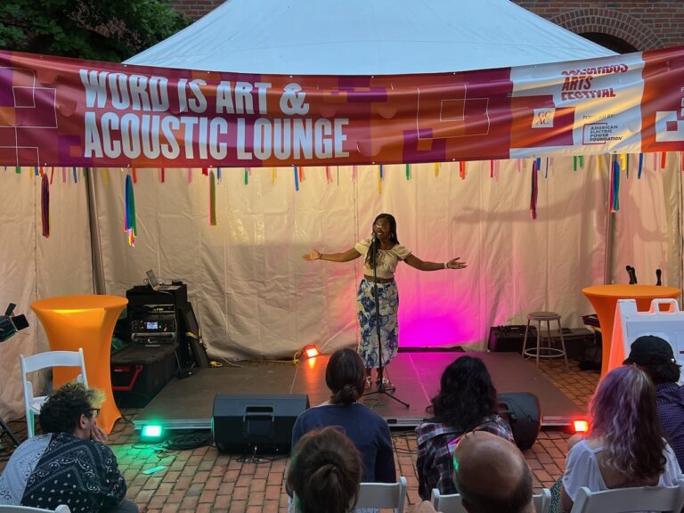 A poet performs on the Word Is Art & Acoustic Lounge stage