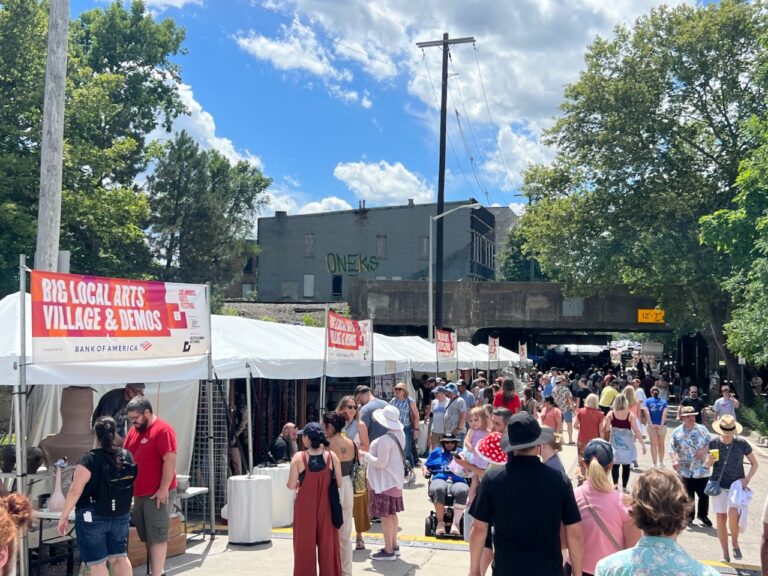 Guests walk Rich Street at the Big Local Arts Village